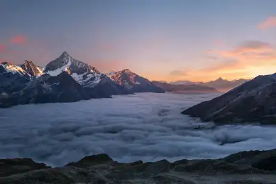 Sonnenaufgang über Alpengipfeln und einem Wolkenmeer
